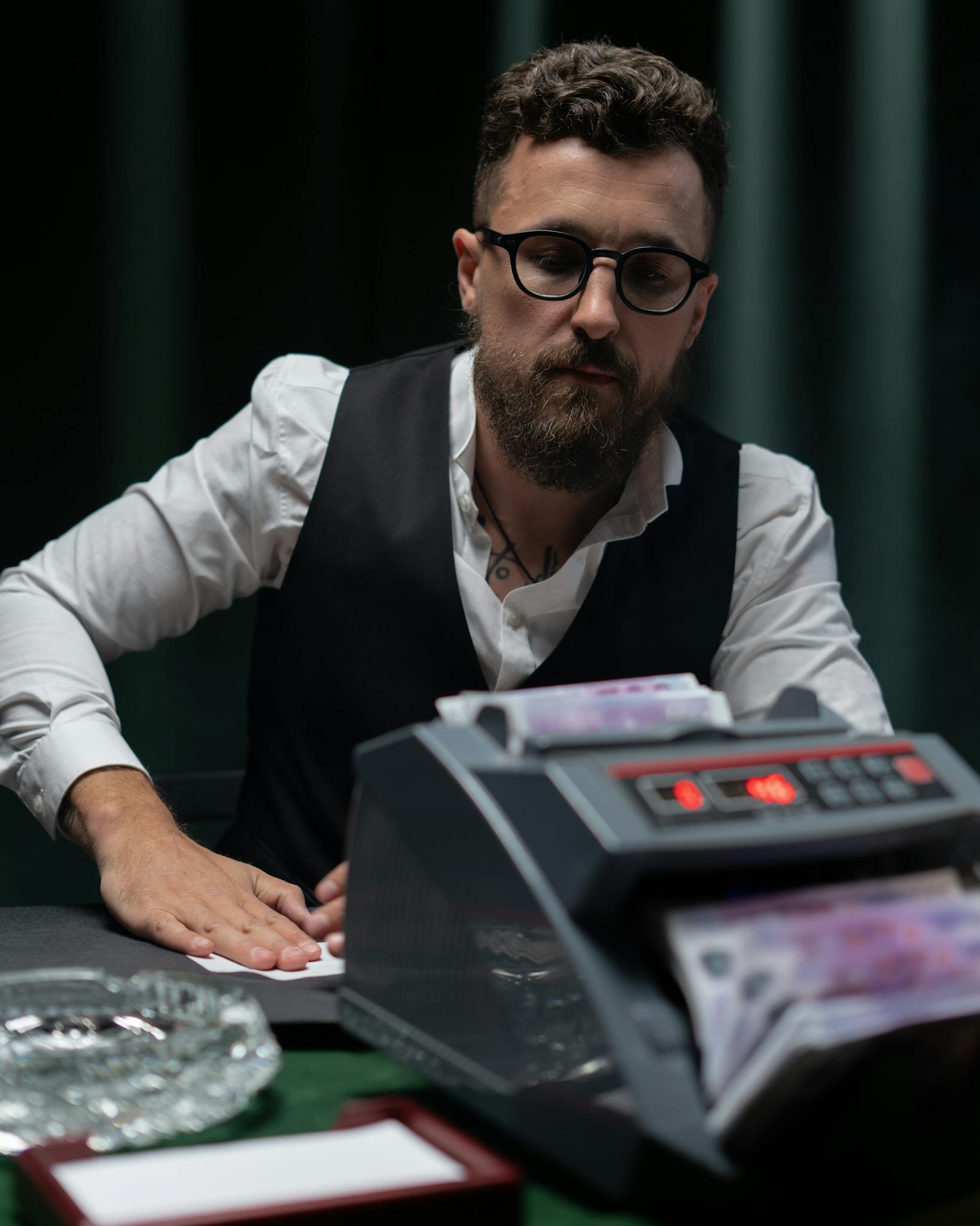 Businessman using a currency counter in office, focused on accuracy and efficiency.